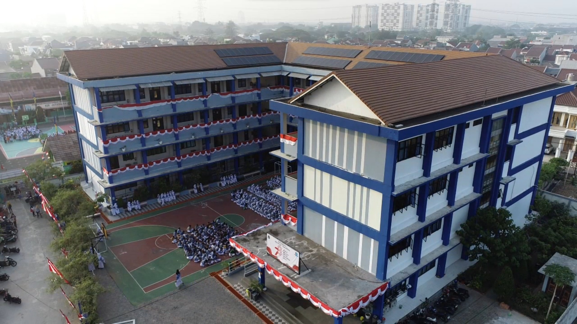 Aerial view of SMKN 71 Jakarta school building with blue and white walls and brown roof